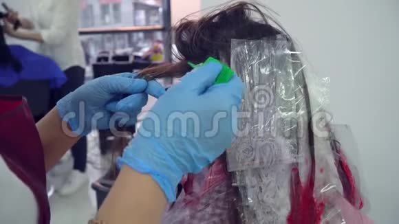 美容院理发店设计师给他的客户画头发女孩坐在镜子前的椅子上特写视频的预览图