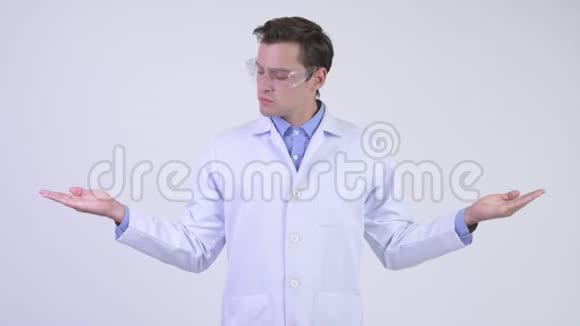 年轻英俊的医生戴着防护眼镜比较一些东西视频的预览图