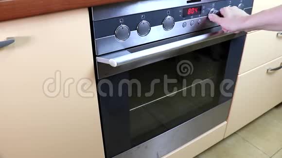 女人转过身来打开炉子烤炉把饭菜放进去煮视频的预览图