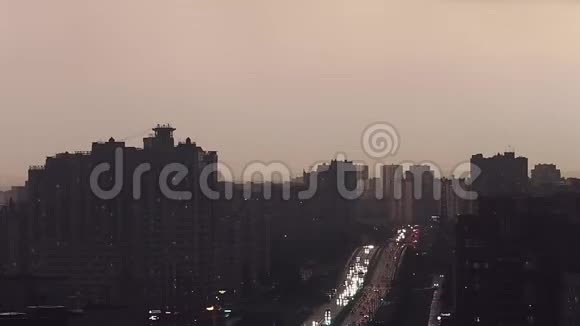 夜晚的城市在阴霾中全景的城市与高速公路汽车走与前灯视频的预览图