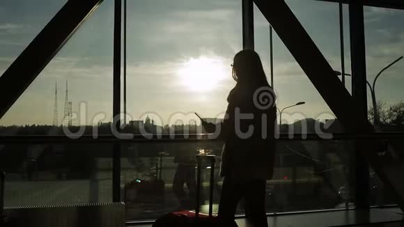 女青年侧影靠全高窗机场航站楼出发区域视频的预览图