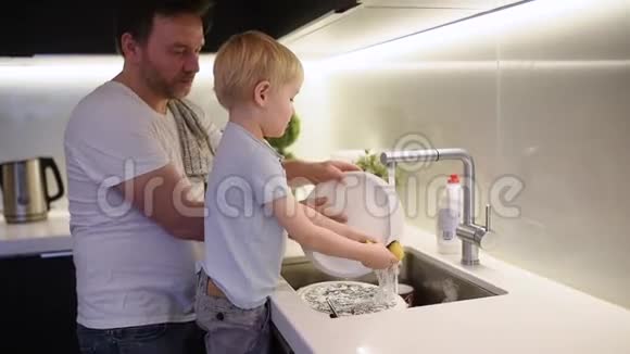 小男孩洗脏盘子孩子在家做清洁的同时还要清洗陶器视频的预览图