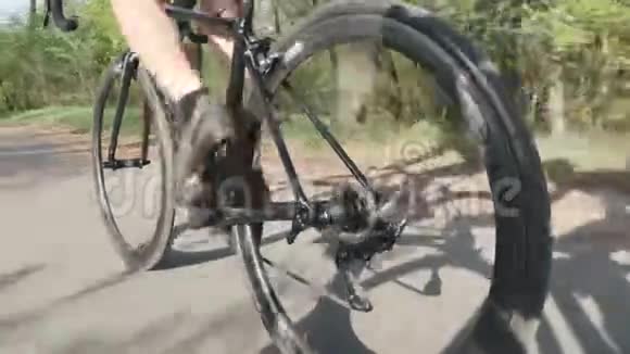骑自行车的骑自行车的人腿部肌肉强壮在自行车上跟随骑自行车的腿的镜头视频的预览图