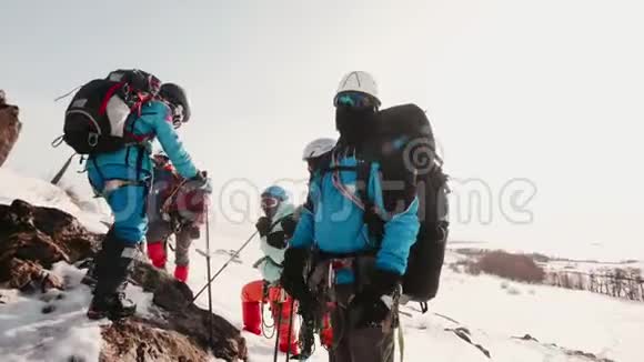 有经验的登山者在白雪皑皑的山顶上停下来休息放松并转换呼吸视频的预览图