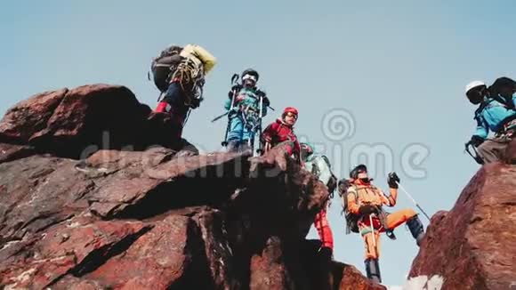 友好的登山队站在山顶欢乐地庆祝他爬上陡峭的山坡享受着视频的预览图