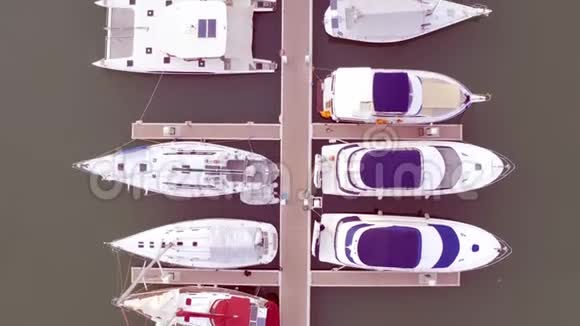 游艇俱乐部和码头的无人机提供空中观景游艇俱乐部的俯视图海水中的白船码头码头游艇和视频的预览图