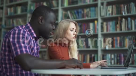 欧洲可爱的女士和带笔记本电脑的非裔美国人视频的预览图