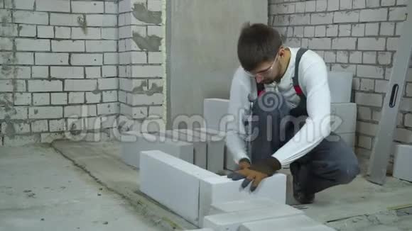建筑工人用橡胶锤打加气混凝土砌块视频的预览图