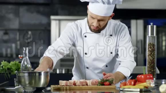 男厨师在厨房里慢动作地腌制肉专业人士烹饪菜肴视频的预览图