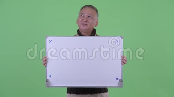 快乐成熟的日本男人拿着白板思考视频的预览图