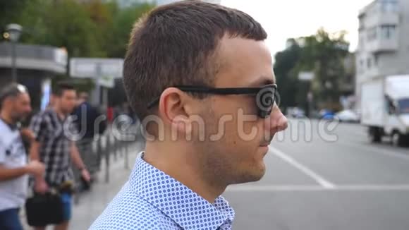 戴太阳镜的年轻商人在市中心过马路自信的男企业家视频的预览图