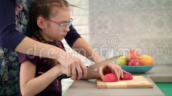 女人帮孩子切苹果片妈妈和女儿一起做饭视频的预览图