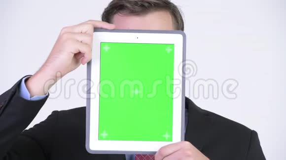 年轻快乐英俊的商人展示数码平板电脑露出一张脸视频的预览图