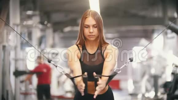 一位在健身房训练的女运动员拉把手抽胸肌视频的预览图