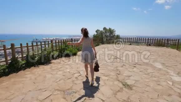 蒙特朱伊山上的幸福女人欣赏大海和巴塞罗那港全景视频的预览图