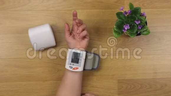 女人的手取出盒子里的血压计在测量桌子上的血压后视频的预览图