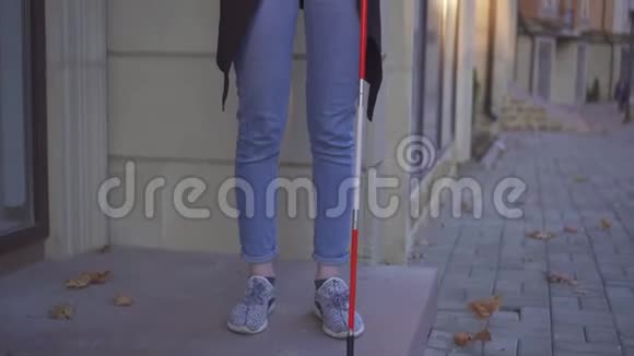 盲人女子手里拿着拐杖站在街上打着电话视频的预览图