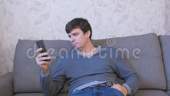 幸福的人正坐在沙发上打电话留言和朋友聊天视频的预览图