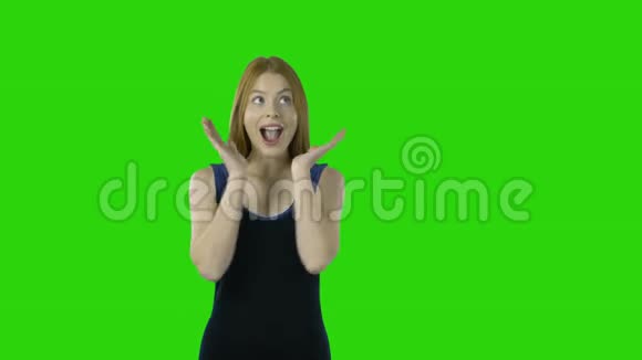一个穿着晚礼服的红长发的年轻女孩羡慕并把双手举到脸上表现出积极的情绪视频的预览图