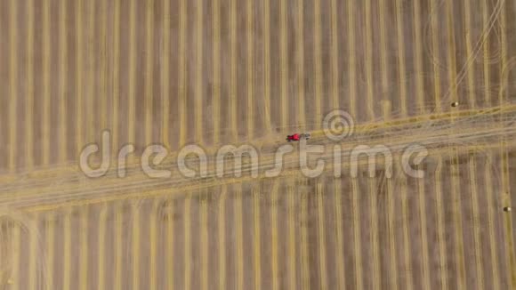 干草加工成圆捆的鸟瞰图红色拖拉机在田间作业以不同速度射击正常视频的预览图