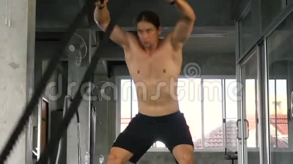 肌肉发达的年轻人训练用战绳做运动在功能训练健身馆视频的预览图