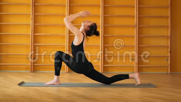 苏里亚纳马斯卡穿黑色紧身衣的女人在楼梯背景的黄色工作室做瑜伽练习健康生活方式视频的预览图