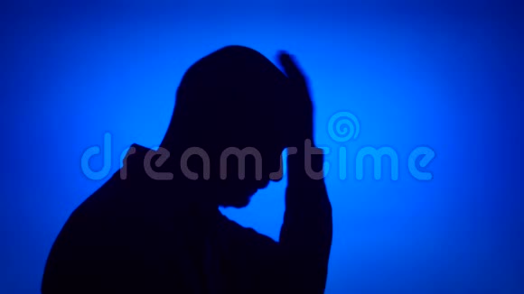资深失意男人的剪影悲伤的男在蓝色背景下绝望地面对着视频的预览图