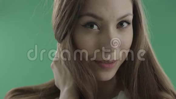 在绿色背景下亲吻一个漂亮的年轻女人视频的预览图