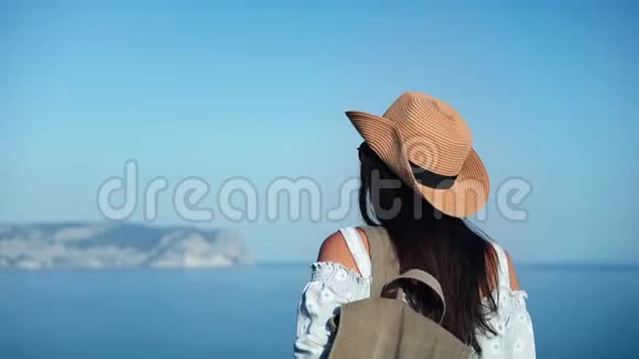戴帽子戴太阳镜的快乐旅游女性欣赏海景享受度假旅行的中型特写视频的预览图