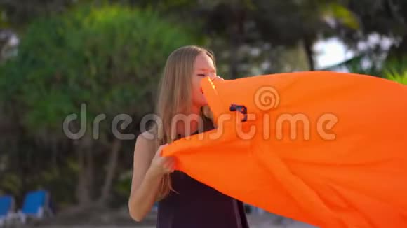 热带海滩上的年轻女子充气沙发暑假概念视频的预览图