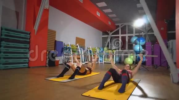 运动女人做腹肌锻炼要有平坦的腹部在健身俱乐部训练在健身房运动漂亮的女人这就是视频的预览图