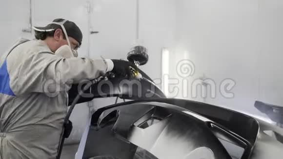 汽车油漆工正独自在汽车服务中心油漆室工作视频的预览图
