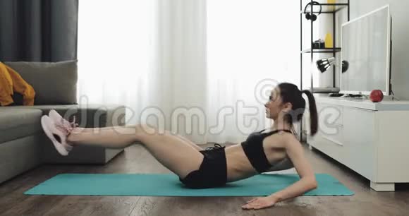年轻女性为健康的生活方式和强壮的腹部在家做健身锻炼健康和运动的生活方式视频的预览图