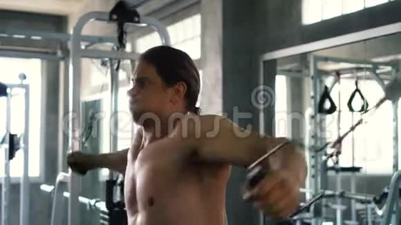 赤膊肌肉男在健身房做有线交叉胸部运动视频的预览图
