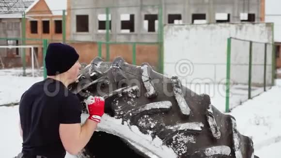 运动员在冬天举起一个大橡胶轮胎做交叉健身运动视频的预览图