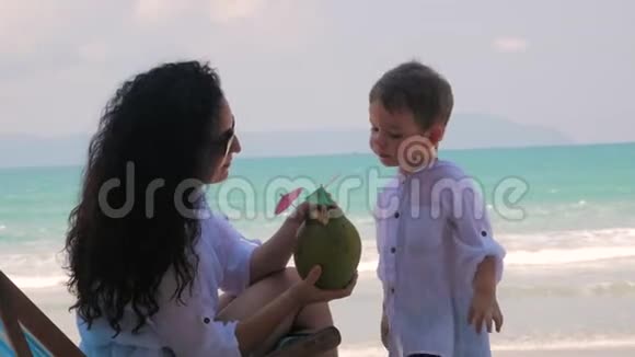 快乐的母亲吃她可爱的小椰子有宝宝在户外家庭幸福童年快乐的概念妈妈视频的预览图
