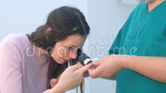 外科医生和病人用皮镜放大镜检查手指上的WART视频的预览图