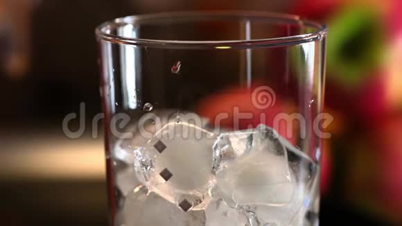 绿埃斯特龙柠檬水倒入鸡尾酒杯与冰块把蓝色的鸡尾酒吸管放进饮料里视频的预览图