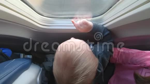 可爱的小宝宝看着从飞机窗口从上面射出来的视频的预览图
