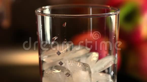 几个冰块加入融化的冰块的鸡尾酒杯视频的预览图