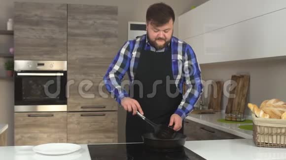 一个留着胡子的白种人在厨房里炸薯条然后取一个样品慢动作视频的预览图