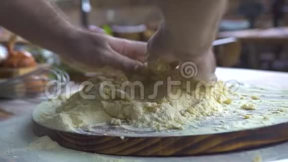 男性手捏面团用于烘焙蛋糕厨师在厨房桌子上为披萨做面团流程视频的预览图