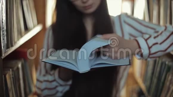 合上一个戴着眼镜的漂亮少女翻阅着书视频的预览图