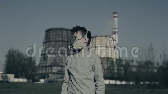 戴防毒面具的小男孩对着工业烟斗拍特写环境污染概念视频的预览图