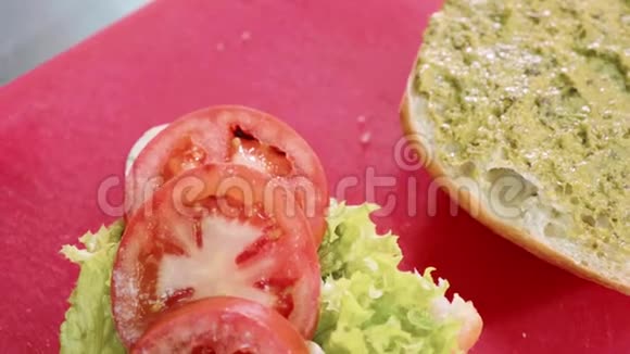 在红色的塑料切割板上用特里亚吉酱浇纯素汉堡视频的预览图