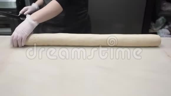 场景厨师用肉桂将面团的两端切掉生产肉桂卷面包制品视频的预览图