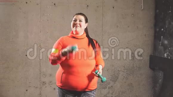 有趣的美丽超重的女人用哑铃工作视频的预览图