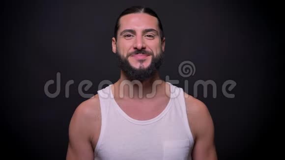 一个身材和胡须都很健康的笑容男人独自站在黑色背景上对着镜头开心地笑视频的预览图