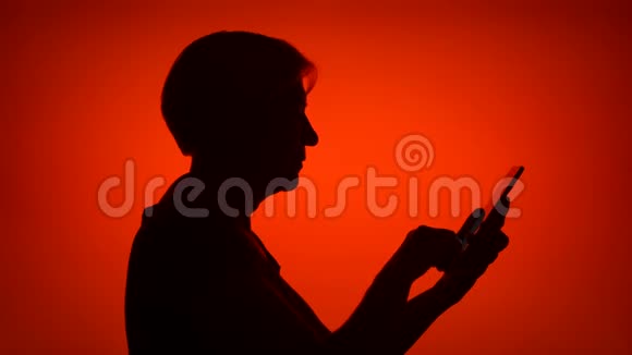 高级女性的剪影在红色背景下使用手机女性在网上浏览个人资料视频的预览图