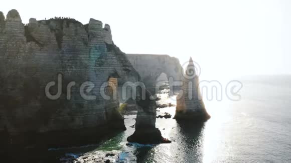 长无人机跟踪拍摄在诺曼底海岸著名的白色悬崖与自然岩石拱门和旅游夫妇视频的预览图